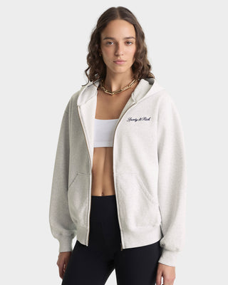 Woman wearing a white jacket with a brand logo on a white background