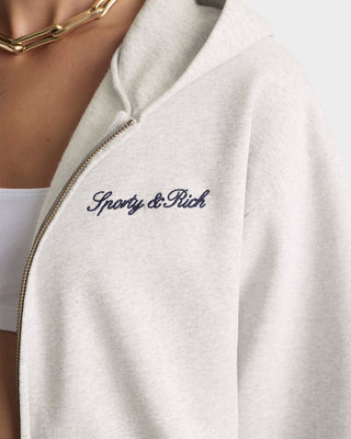 White jacket with 'Sporty & Rich' embroidery on a blurred background