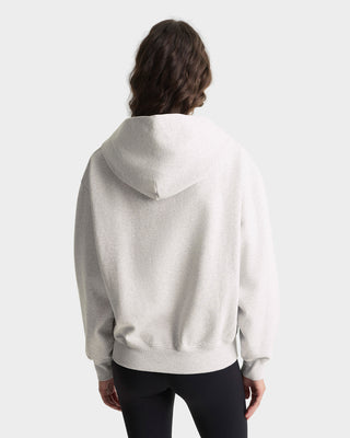 Person wearing a light gray hoodie from behind on a white background