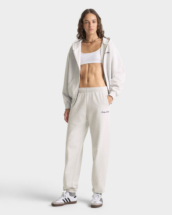 Person wearing a white tracksuit with a visible brand logo on a light gray background