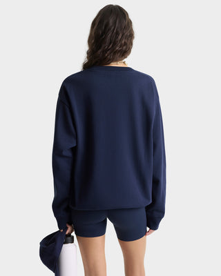 Person wearing a navy blue sweatshirt and shorts on a white background