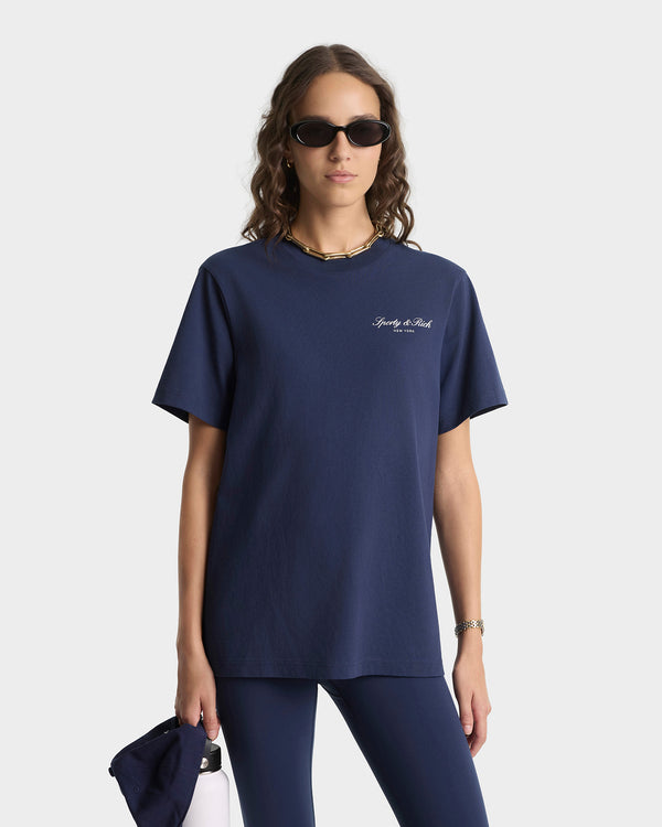 Person wearing a navy blue t-shirt with a logo on a white background