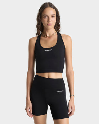 Woman wearing a black sports bra and shorts set with 'Sculpted by Nature' branding on a white background