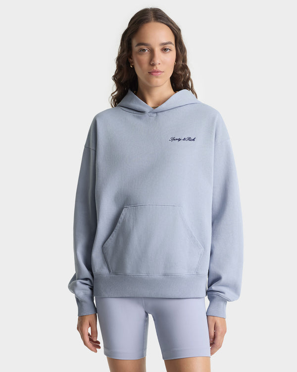 Person wearing a light blue hoodie and shorts set on a white background
