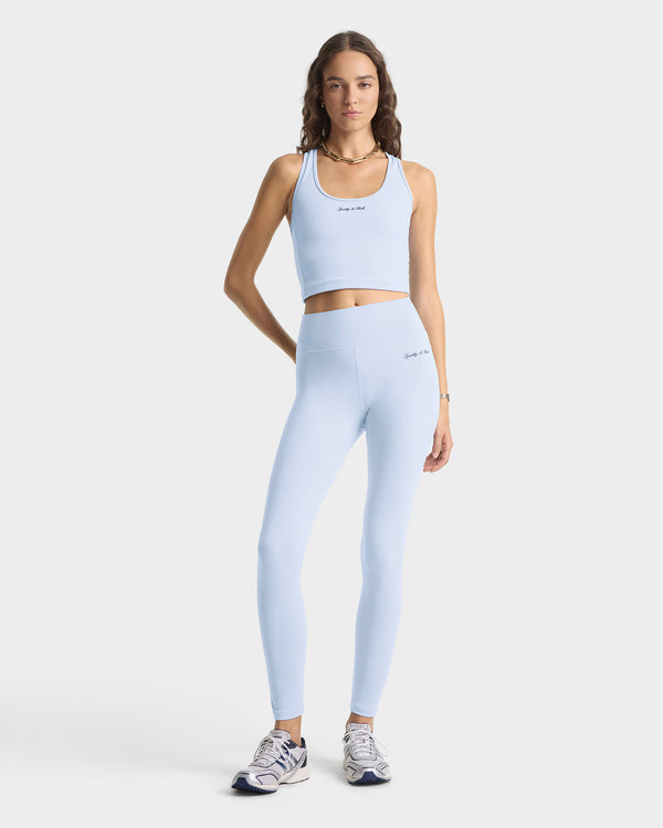 Woman wearing a light blue athletic outfit on a white background