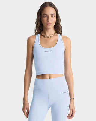 Woman wearing a light blue sports bra and leggings set on a white background
