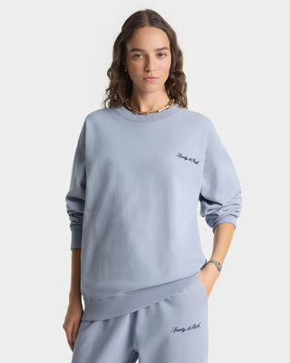Person wearing a light blue sweatshirt and pants with text on a white background