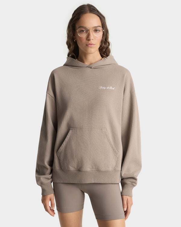Woman wearing a beige hoodie with text on a white background