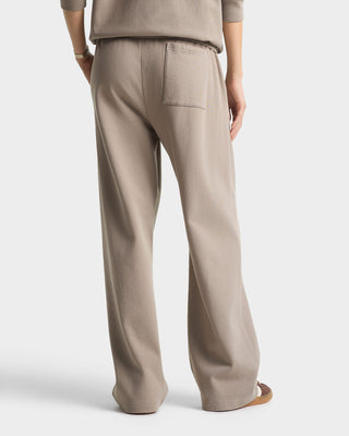 Beige pants worn by a person on a white background