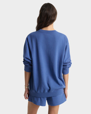 Person wearing a blue sweatshirt and shorts set on a white background