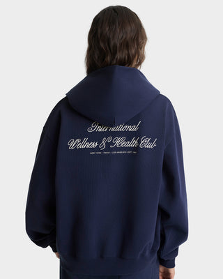 Person wearing a navy hoodie with text on the back against a white background