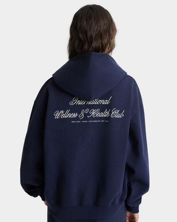 Person wearing a navy hoodie with text on the back against a white background