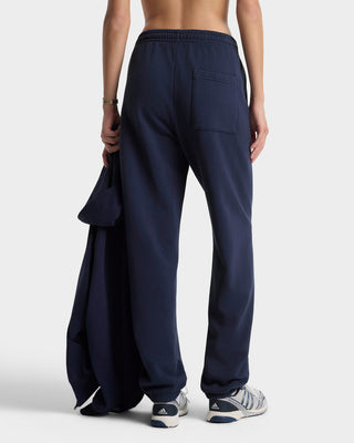Person wearing navy blue sweatpants with a white background
