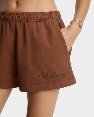 Brown shorts with 'Wellness' text on a neutral background