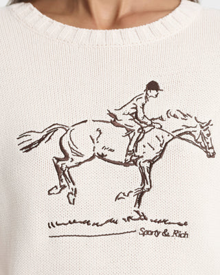 White sweater with a brown horse and rider illustration and 'Sporty & Rich' branding.