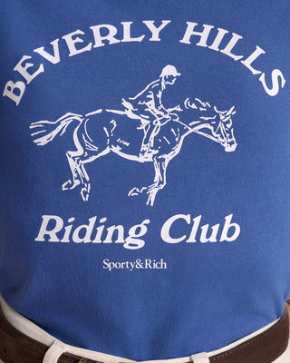 Blue jacket with white 'Beverly Hills Riding Club' text and horse graphic, brand 'Sporty&Rich' visible.