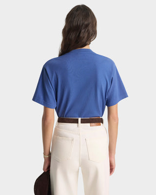 Person wearing a blue shirt and beige pants on a white background