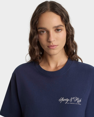Person wearing a navy blue sweatshirt with a logo on a white background