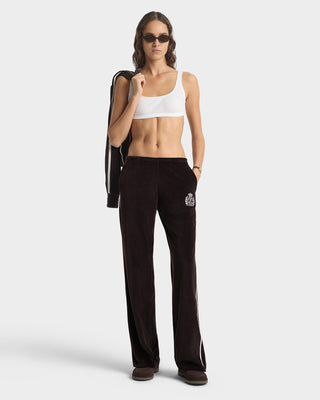 Woman wearing a white sports bra and black pants on a white background