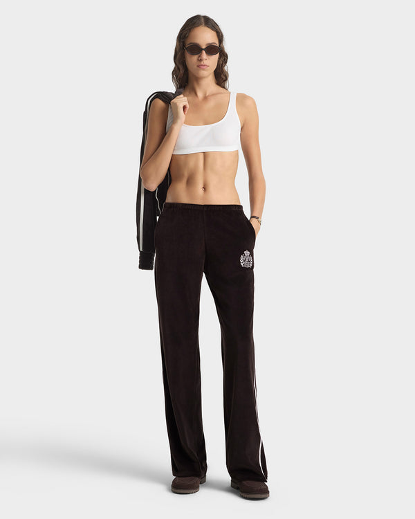 Woman wearing a white sports bra and black pants on a white background