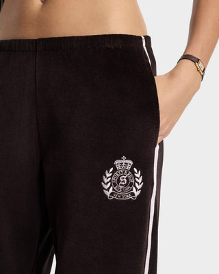 Black pants with a white logo and trim on a light gray background