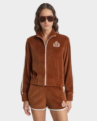 Woman wearing a brown tracksuit with a logo on a white background