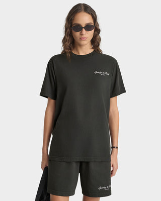 Person wearing a black t-shirt and shorts with a brand logo on a white background