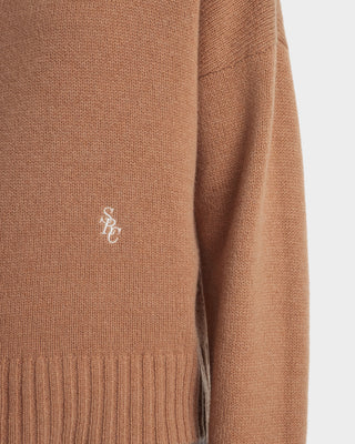 Brown sweater with a logo on a light gray background