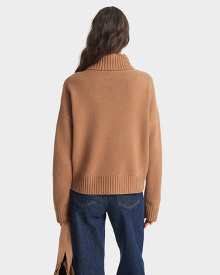 Person wearing a brown sweater and blue jeans on a white background