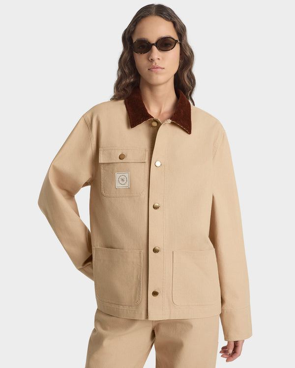 Person wearing a beige jacket with a brown collar on a white background