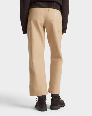 Beige pants worn by a person on a white background