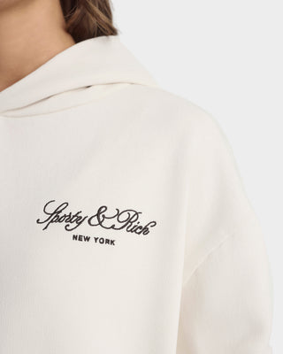 White polo shirt with 'Sporty & Rich New York' logo on a white background