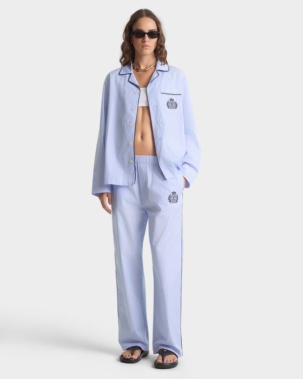 Woman wearing a light blue pajama set with a white background