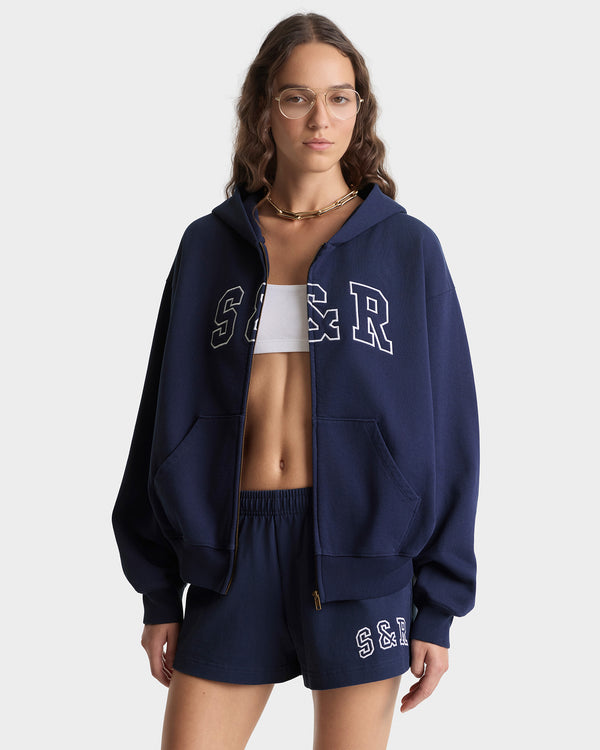 Person wearing a navy blue hoodie and shorts with 'S&F' branding on a white background