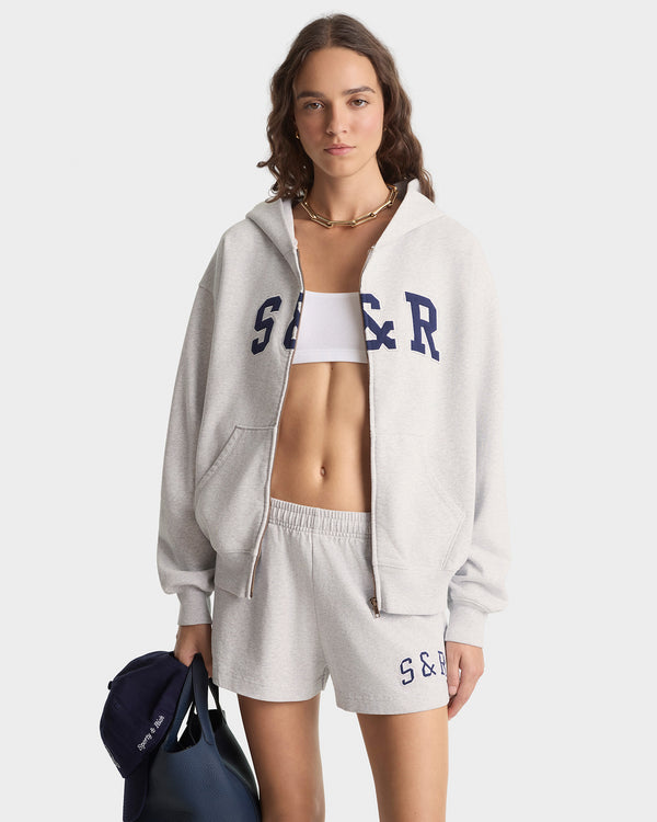 Woman wearing a gray tracksuit with 'S & R' branding on a white background