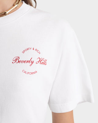 White t-shirt with red 'Sporty & Rich Beverly Hills California' text on a white background