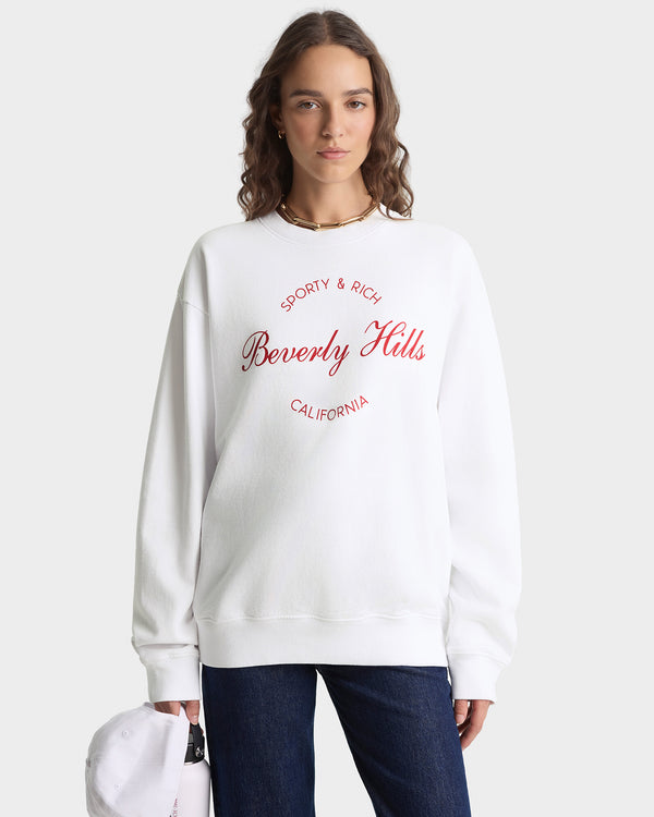 Person wearing a white sweatshirt with red text on a white background