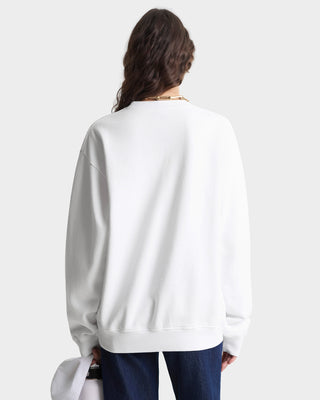 Person wearing a white sweatshirt with a plain background