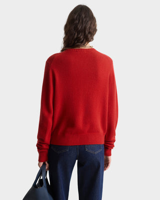 Person wearing a red sweater and blue jeans on a white background