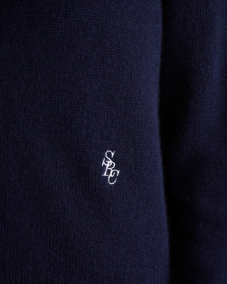 Navy blue fabric with a small white logo on a dark background