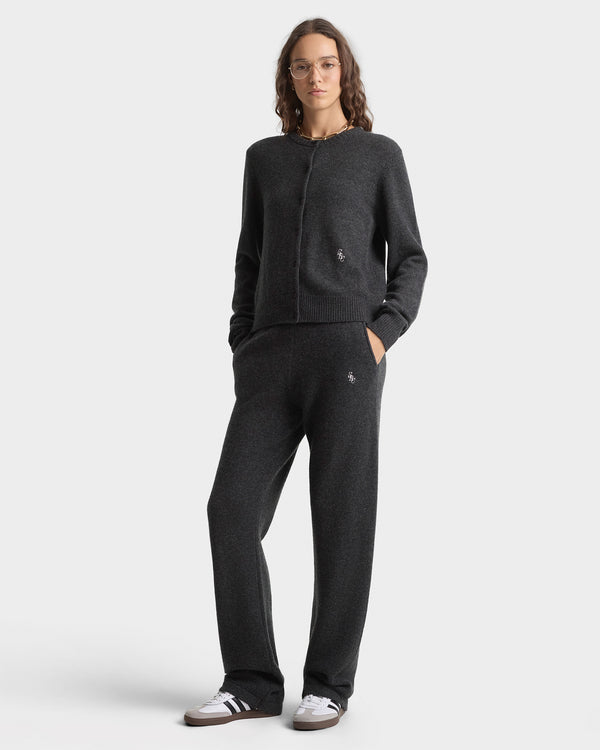 Person wearing a black sweater and pants set on a white background