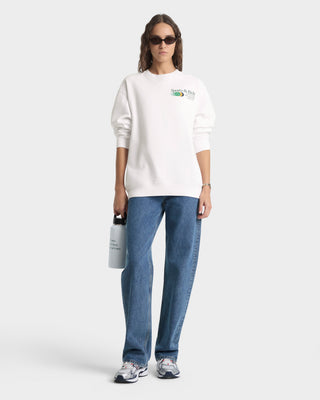 Person wearing a white sweatshirt and blue jeans on a white background
