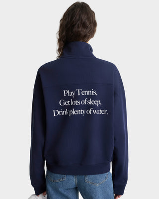 Navy blue jacket with text on the back, worn by a person against a white background