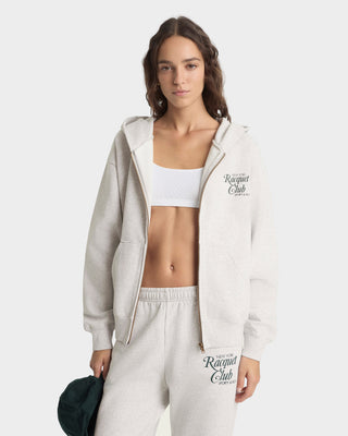 Woman wearing a gray 'Racquet Club' tracksuit on a white background