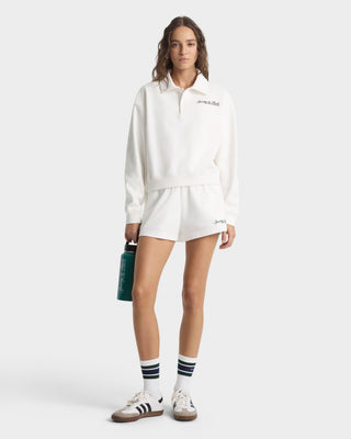 Person wearing a white outfit with a visible brand logo on a white background