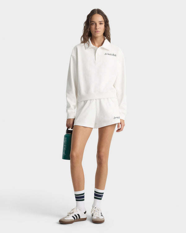 Person wearing a white outfit with a visible brand logo on a white background