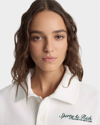 Woman wearing a white coat with 'Sporey & Rich' branding on a plain background