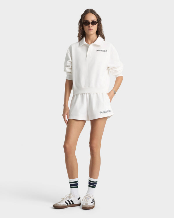 Person wearing a white outfit with brand logos on a white background