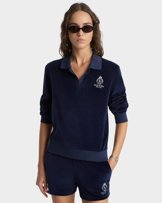 Woman wearing a navy blue outfit with a logo on a white background