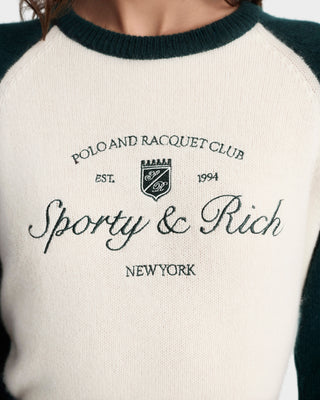 Close-up of a sweater with 'Sporty & Rich' branding on a white background
